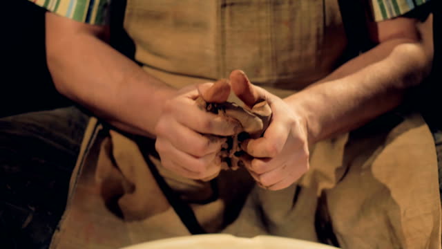 Strong-potters-hands-knead-a-piece-of-clay.