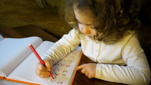 Kleines-Mädchen-schreiben-und-Zeichnung-machen-Hausaufgaben