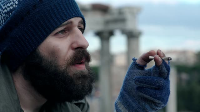 traurig-und-nachdenklich-Obdachlosen-Mann-zündet-sich-eine-Zigarette