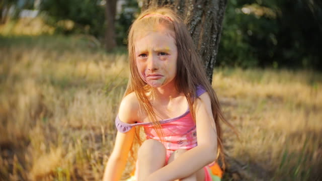 Little-girl-smeared-with-colours-of-Holi-crying-sitting-in-a-tree