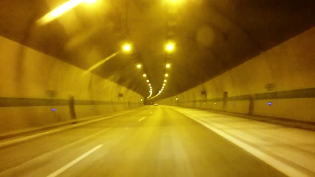 Car-fast-in-tunnel-with.-Traffic-on-mountain-road.