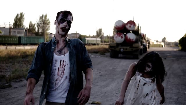 Halloween-horror-filming-concept.-Picture-of-creepy-male-and-female-ghost-or-zombie-walking-with-wounded-face.-Industrial,-abandoned-town-on-the-background