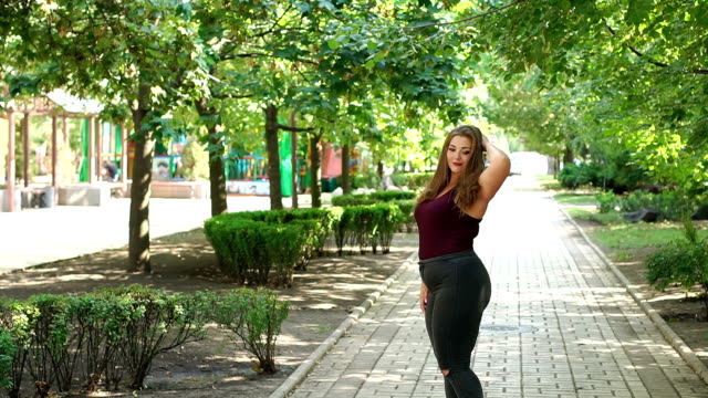 Mädchen-Modell-Übergewicht-posiert-in-einem-sonnigen-Sommer-City-Park.-Slow-Motion.