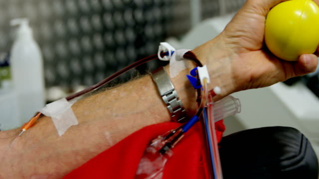 Médico-comprobar-a-senior-hombre-donar-sangre-4k