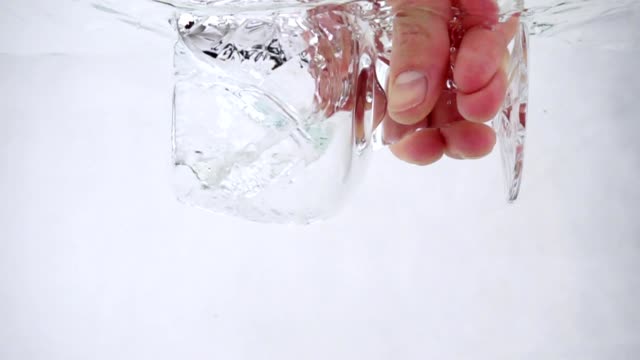 A-man-holds-a-goblet-in-his-hand-and-pours-water-into-it,-close-up-slow-motion