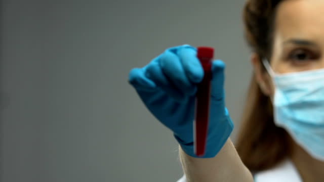 Doctora,-sujetando-el-tubo-de-ensayo-con-conciencia-de-enfermedad-infecciosas,-muestra-de-sangre