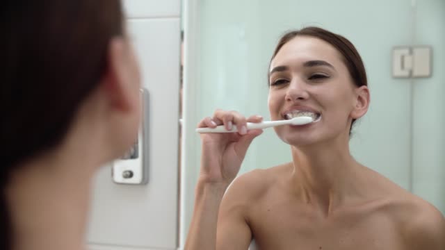 Zahngesundheit.-Frau-putzen-Zähne-im-Badezimmer