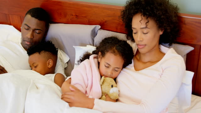 Vorderansicht-des-schwarzen-Familie-schlafen-im-Schlafzimmer-zu-Hause-4k
