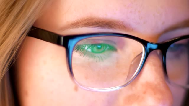 Close-up-shooting-caucasian-woman-is-looking-at-screen-reflected-in-her-glasses,-IT-specialist,-smart-modern-person