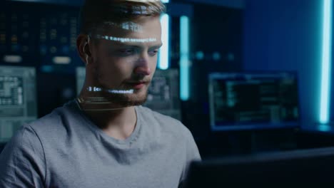 Handsome-Young-Software-Developer-Working-on-Personal-Computer-in-Digital-Identity-Cyber-Security-Data-Center,-Program-Coding-Language-Reflects-on-His-Face.-Futuristic-Hacking-and-Programming-Concept