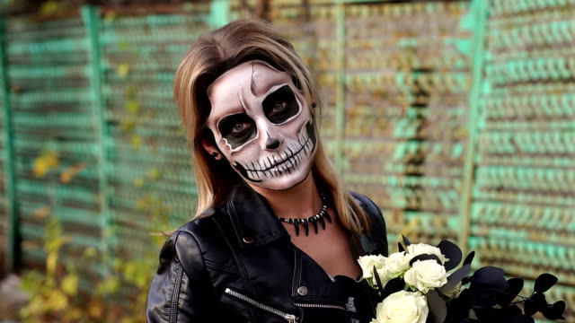 Creepy-bride-with-a-bouquet-of-black-flowers-and-make-up-in-the-form-of-a-skull