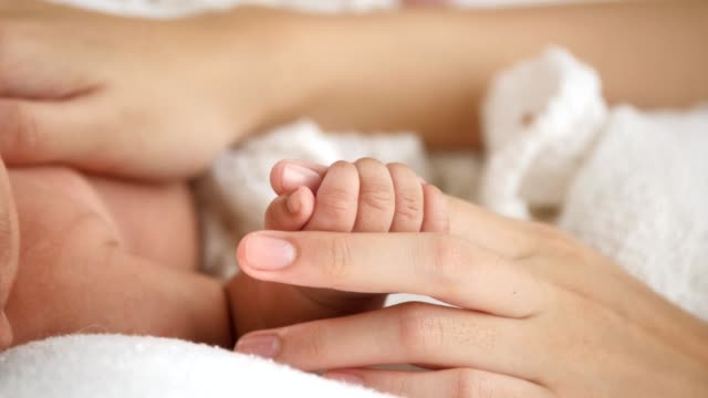 Close-up-newborn-baby-holding-mother's-hand