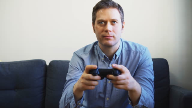 Man-playing-racing-video-game-on-TV.-Gamepad-controller-in-hands.