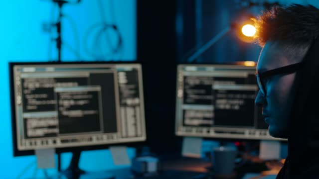 Asian-Hacker-in-dunklem-Raum-mit-Computern-in-der-Nacht