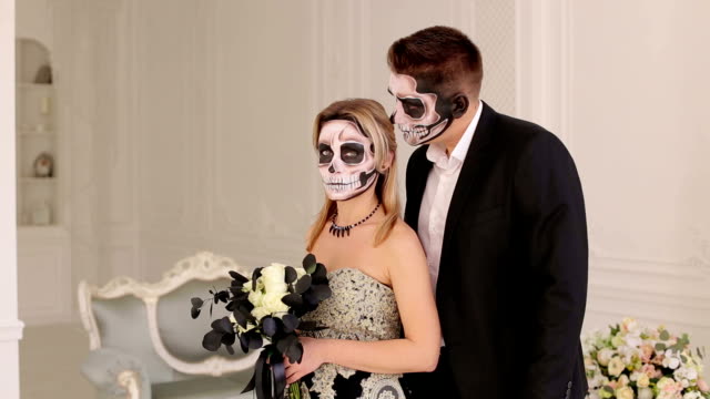 Couple-with-halloween-skull-make-up-in-a-dress-in-a-room-with-vintage-interior.