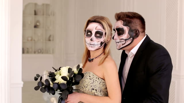 Halloween-couple,-woman-and-man-with-skull-make-up.-Halloween-face-art.