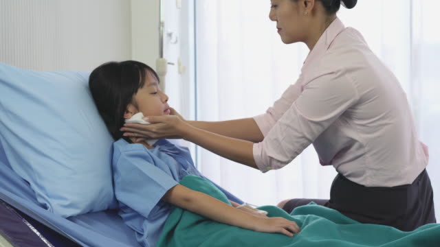 Asiatische-Mutter-reiben-den-Körper-Patient-kleines-Mädchen-für-die-Temperatur-und-körperliche-Untersuchung-im-Krankenhaus-zu-reduzieren.-Konzept-der-Familie,-Medizin,-Gesundheitswesen-und-Technologie.