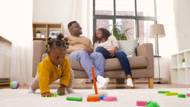 african-baby-girl-playing-with-toy-blocks-at-home