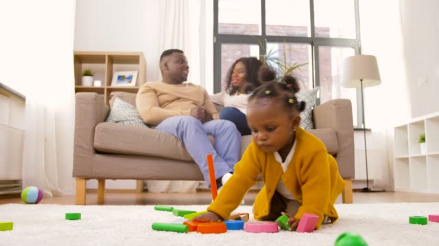 african-baby-girl-playing-with-toy-blocks-at-home