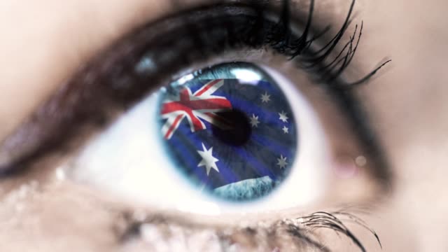 Frau-blaues-Auge-in-Nahaufnahme-mit-der-Flagge-von-Australien-in-Iris-mit-Windbewegung.-Videokonzept
