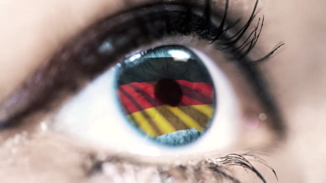 Frau-blaues-Auge-in-Nahaufnahme-mit-der-Flagge-von-Deutschland-in-Iris-mit-Windbewegung.-Videokonzept
