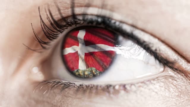 Frau-grünes-Auge-in-Nahaufnahme-mit-der-Flagge-von-Dänemark-in-Iris-mit-Windbewegung.-Videokonzept