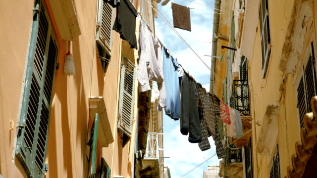 Clothes:-t-shirts,-trousers,-shirts,-linen-hanging-on-a-rope-to-dry-outdoors.-4K