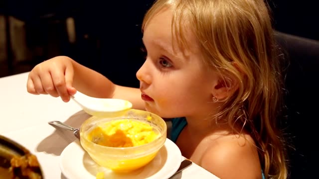 Child-little-girl-eating-dessert-by-spoon.