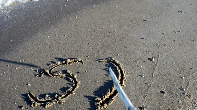 Die-Inschrift-SOS-auf-Sand-Shooting-am-Strand.