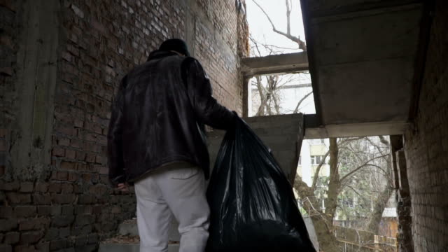 Schmutzige-Obdachlosen-mit-Abfallsack-in-verlassenen-Gebäude-Treppen