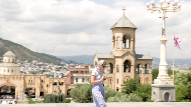Young-girl-looking-at-Holy-Trinity-Cathedral-of-Tbilisi-Tsminda-Sameba---Georgia