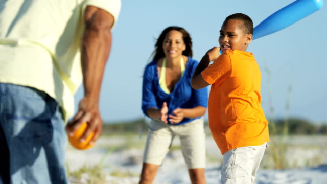 Afroamerikanische-Familie-spielen-Baseball-auf-Strandurlaub