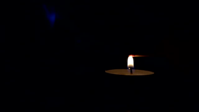 Lighting-a-match-stick-from-a-candle-in-the-dark,-slow-motion
