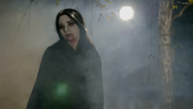 Durstig-jungen-weiblichen-Vampir,-die-sich-aus-dem-Wald-auf-die-Jagd-und-zeigen-ihre-Zähne-der-Halloween-Nacht