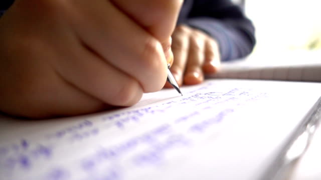Child-hands-writing-a-letter,-close-up-slow-motion