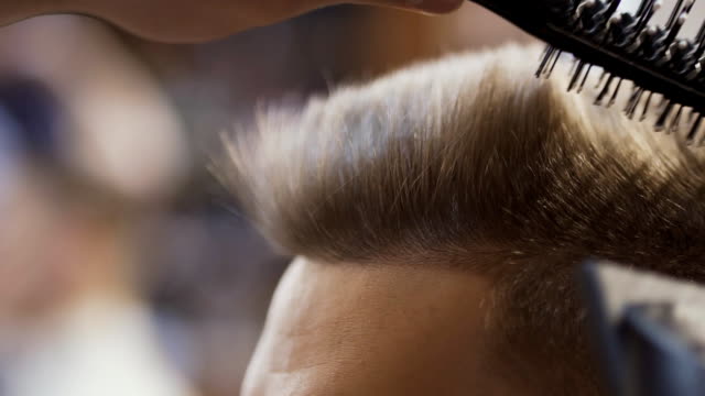 Stylist-dries-hair-with-hairdryer-in-salon