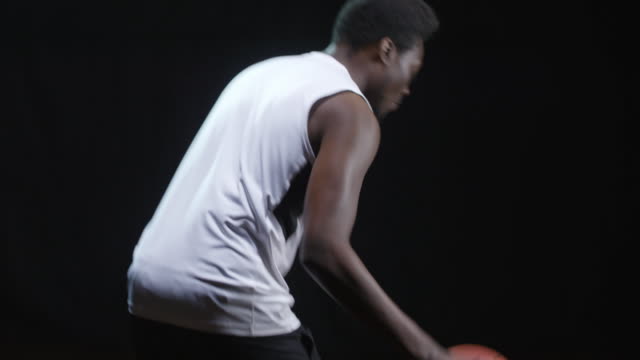 Jugador-de-baloncesto-lanza-bolas-sobre-fondo-negro