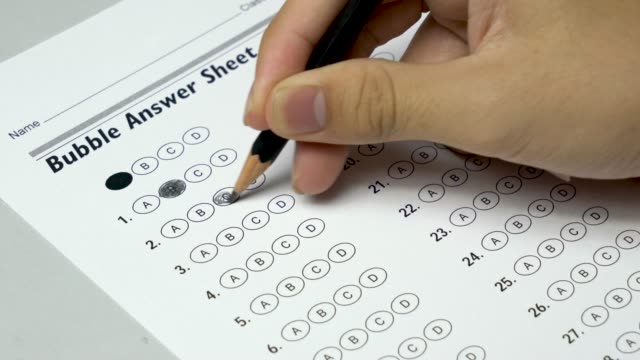 Asiatische-Studentin-Hand-tun-Prüfung-Test-mit-standardisierten-Testform-und-Antworten-sprudelte.