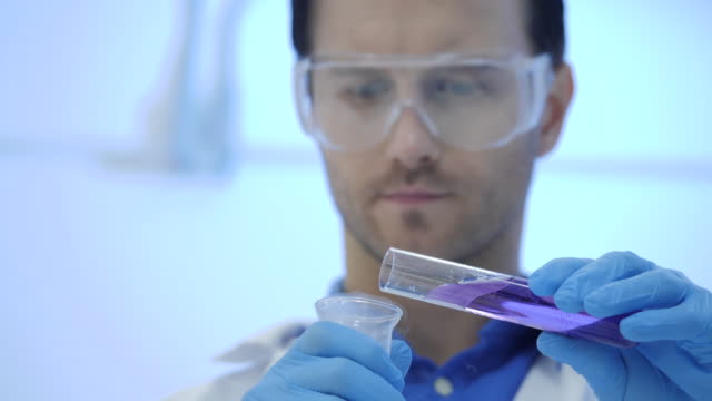 Científicos-de-investigación-médica-masculina-en-mezclas-de-gafas-fumar-líquidos-en-un-vasos