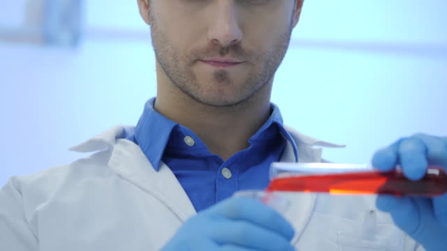 Científicos-de-investigación-médica-masculina-mezcla-líquidos-de-fumar-en-un-vasos