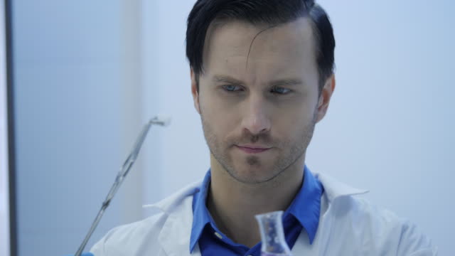 Investigadores-médicos-masculinos-ponen-hielo-seco-en-un-vaso-de-vidrio