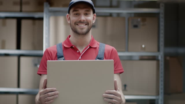 Trabajador-almacén-guapos-de-uniforme-tiene-sonrisas-y-paquete-de-la-caja-de-cartón.
