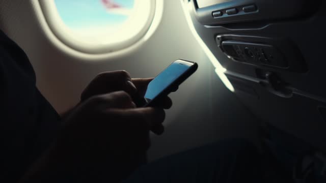 Hombre-usando-el-teléfono-inteligente-en-un-avión,