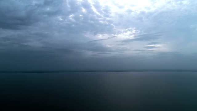 The-flight-above-the-picturesque-sea-on-the-rainy-cloud-background.-time-lapse