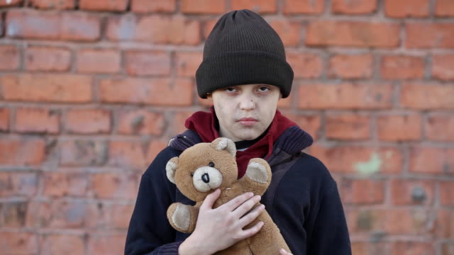 Obdachloser-junge-hält-einen-Teddybär