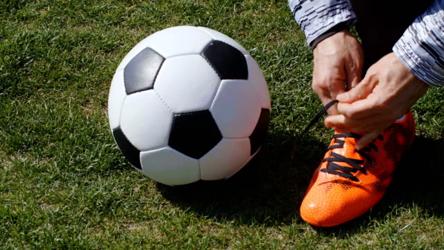 Fußball,-Fußball-Spiel.-Profi-Fußballer-Schnalle-seine-roten-Schuhe-vor-dem-Training,-4k