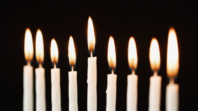 Cerca-de-nueve-velas-ardiendo-para-la-festividad-judía-de-Hanukkah,-enfoque-selectivo