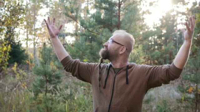 Portrait-of-a-young-man-with-a-beard-who-raised-his-hands-up-to-the-sky.-The-concept-of-joy-and-happiness