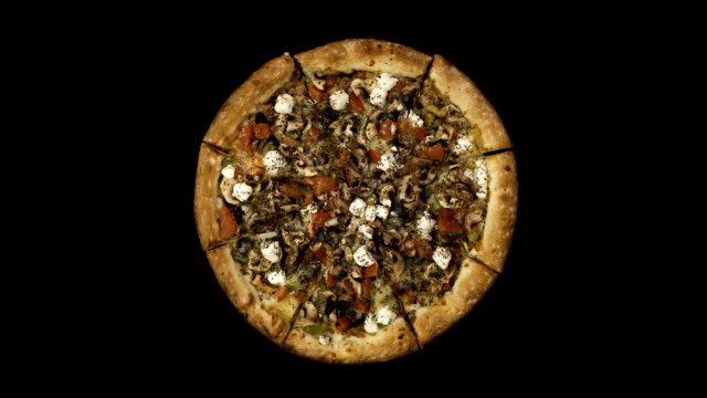 Rotating-pizza-with-smoked-sausage-and-olives-on-a-black-background.-Top-view-center-orientation