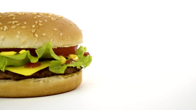 Rotación-de-una-apetitosa-hamburguesa-sobre-un-fondo-blanco